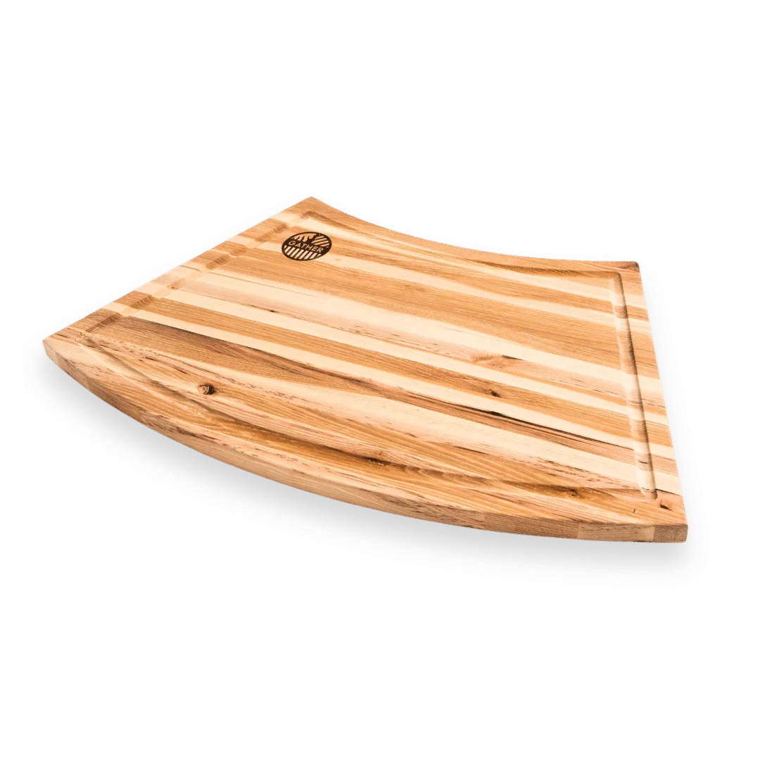 Curved striped wood cutting board with juice groove on a white background